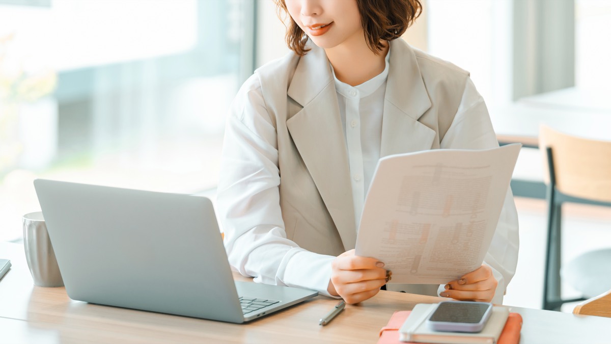 書類を手に取り、内容を確認している女性