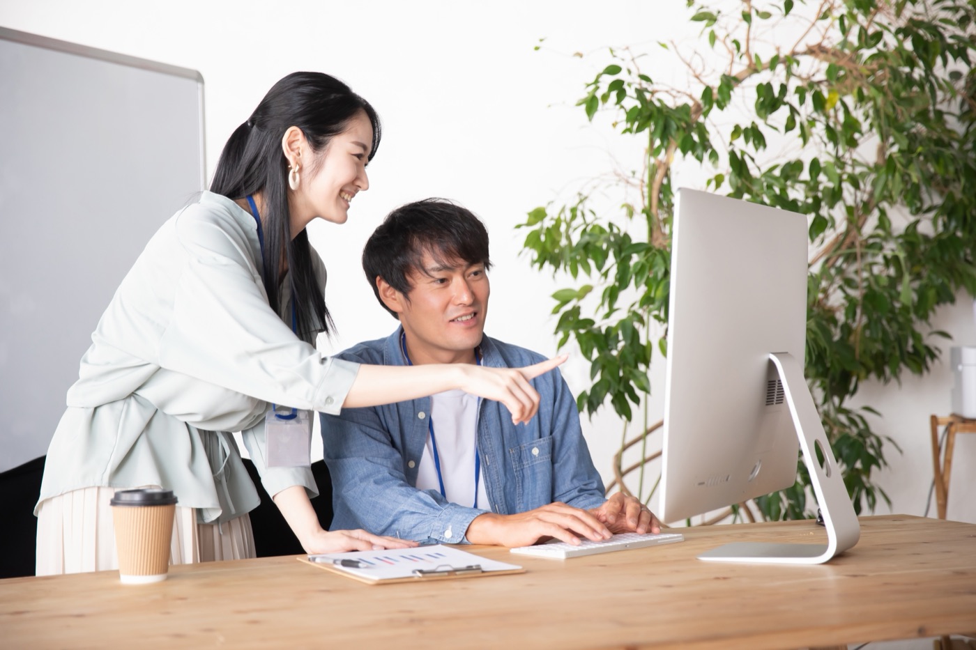 パソコンの画面を見ながら、となりで教えているスタッフ